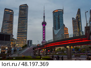 Shanghai, China - 1 April 2025: Night view of Pudong with Oriental Pearl Tower glowing. Bright city lights and illuminated bridges showcase Shanghai's modernity. Редакционное фото, фотограф Татьяна Терехина / Фотобанк Лори