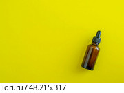 Bottle for cosmetics on a yellow background. Beauty saloon. Background with copy space. Стоковое фото, фотограф Юлия Николаева / Фотобанк Лори