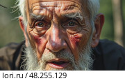 A close-up of an old man's face streaked with sadness and thoughtful as he listens to a lamentation song, the shadows of tree branches dancing across his face. Стоковое AI-видео, аниматор Sergey Grishin / Фотобанк Лори