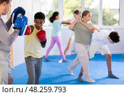 African american boy in boxing gloves practicing punches on mitts with coach. Стоковое фото, фотограф Яков Филимонов / Фотобанк Лори