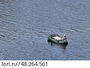 Одинокий рыбак развалясь в шлюпке ловит рыбу на водном пространстве. (2024г.) Стоковое фото, фотограф Вера Смолянинова / Фотобанк Лори