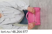 The girl at the table opens and shows a large pink women's cosmetic bag. Стоковое видео, видеограф Катерина Белякина / Фотобанк Лори