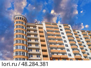 Современный многоэтажный красивый дом на фоне голубого неба. Modern panel apartment building on background of blue sky. Стоковое фото, фотограф Татьяна Д / Фотобанк Лори