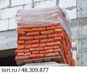 Кирпичи из красной глины уложенные на деревянные поддоны. Red clay bricks are stacked on wooden pallets. Стоковое фото, фотограф Татьяна Д / Фотобанк Лори