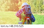 Geodesist after summer day performs geodetic work. Стоковое фото, фотограф Скрипачев Антон / Фотобанк Лори