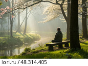 A man sits in a meditative pose on a bench by a stream in a quiet, foggy park. Mental health issues. Стоковое AI-изображение, AI-художник Коханова Наталья / Фотобанк Лори