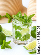 Refreshing mojito cocktail with lime, mint and ice cubes on white background. Стоковое AI-изображение, AI-художник Юрий Поздников / Фотобанк Лори