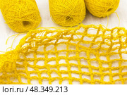Yellow colored skeins of jute twine for crocheting on white wooden background. Стоковое фото, фотограф Татьяна Васильева / Фотобанк Лори