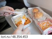 Enjoying InFlight Meal Experience Featuring Rice and Rolls Served on an Airplane Tray During the Flight. enjoying a delicious inflight meal with rice and fresh bread rolls, served on an airplane tray. Стоковое фото, фотограф Владимир Разгуляев / Фотобанк Лори