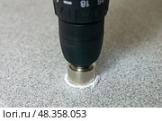 Rotating diamond-coated hole saw in drill drills stone slab. Стоковое фото, фотограф Евгений Харитонов / Фотобанк Лори