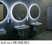 Interior of modern public toilet with white sinks and led lights. Стоковое фото, фотограф Евгений Харитонов / Фотобанк Лори