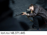 Девушка смотрит в прицел снайперской винтовки на фестивале косплея в городе Москве, Россия. Редакционное фото, фотограф Николай Винокуров / Фотобанк Лори