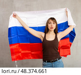 Sad young woman holding flag of Russia against unicoloured background. Стоковое фото, фотограф Яков Филимонов / Фотобанк Лори