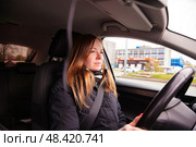 Mindful Journey of a Woman Driving Through a Vibrant Urban Landscape on a Sunny Day. Стоковое фото, фотограф Aleksandr Golubev / Фотобанк Лори