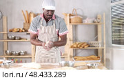 Experienced African baker cutting dough on floured surface, preparing fresh bread in cozy artisan bakery kitchen, highlighting craftsmanship of traditional breadmaking. Стоковое видео, видеограф Яков Филимонов / Фотобанк Лори