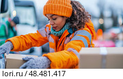 Winter Dispatch: Female Courier Carefully Loads Cardboard Boxes for Speedy Delivery. Стоковое AI-изображение, AI-художник Данила Большаков / Фотобанк Лори