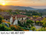 Golden sunrise illuminating picturesque tuscan style village in rolling hills. Стоковое AI-изображение, AI-художник Иван Рябоконь / Фотобанк Лори