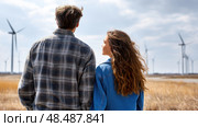Father and daughter looking at solar panels. Solar farm and sunlight at sunset. Solar energy for green energy. Sustainable renewable energy. Photovoltaic power plant or solar park. Energy sustainability. Стоковое AI-изображение, AI-художник ALLA YURTAYEVA / Фотобанк Лори