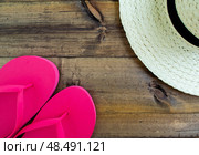 Summer vacation, flatlay. Hat and flip flops on a dark wooden background. Стоковое фото, фотограф Юлия Николаева / Фотобанк Лори
