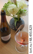 Russia, St.Petersburg, 24 April 2025: bottle of champagne is on table, flowers, wine glass in the restaurant, local lighting, wine cabinet, decanters for sparkling wine. Редакционное видео, видеограф Vladimir Drozdin / Фотобанк Лори