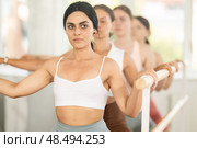 Young girl practicing plie position holding by ballet barre in group. Стоковое фото, фотограф Яков Филимонов / Фотобанк Лори
