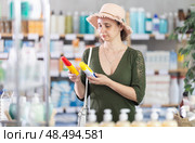 Middle-aged woman choosing repellent in chemist's shop. Стоковое фото, фотограф Яков Филимонов / Фотобанк Лори