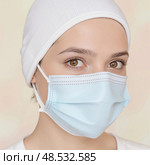 Woman wearing a blue mask, highlighting health and safety practices. Стоковое AI-изображение, AI-художник Екатерина Борисова / Фотобанк Лори