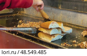Street food vendor slicing and grilling traditional Turkish kokorec at a local food stall. Стоковое видео, видеограф Дмитрий Наумов / Фотобанк Лори