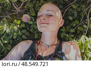 Calm bald woman lying down on the ground with her eyes shut in relaxation or meditation. Стоковое AI-изображение, AI-художник Данила Большаков / Фотобанк Лори