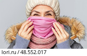 Mature woman holding a pink scarf and covering her face with it. Стоковое AI-изображение, AI-художник Данила Большаков / Фотобанк Лори