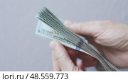 shuffling stack pack of hundred 100 dollar bills on light grey background. Стоковое видео, видеограф Olesia Kondrateva / Фотобанк Лори