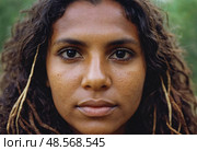 A young Aboriginal Australian woman stands confidently, her hair adorned with natural accents Generative AI. Стоковое AI-изображение, AI-художник Юлия Петровская / Фотобанк Лори