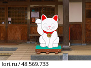 Tokyo, Japan - Sep 30 2024, Close-up view of the flat plywood figure of the beckoning white cat Maneki Neko, at the entrance to Gotokuji Temple, at daytime, without people, Tokyo, Japan. Редакционное фото, фотограф Сергей Богомяко / Фотобанк Лори