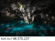 Stunning cave interior showcasing stalactite formations and lake water. Стоковое фото, фотограф EugeneSergeev / Фотобанк Лори
