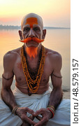 Indian sadhu meditating by the river ganges at sunrise. Стоковое AI-изображение, AI-художник Юрий Поздников / Фотобанк Лори
