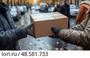 Two individuals in winter attire hand over a package amidst fallen leaves on a bustling urban street during fall. Стоковое AI-изображение, AI-художник Данила Большаков / Фотобанк Лори