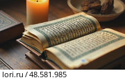 A close-up of a dusty Qur'an resting on a wooden stand, Koran pages open to a verse about sacrifice, bathed in soft candlelight. Quran. Стоковое AI-видео, аниматор Sergey Grishin / Фотобанк Лори