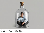 Man sits inside a glass bottle with a cork. Стоковое AI-изображение, AI-художник Дмитрий Киселёв / Фотобанк Лори