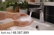 Hands lathering soap under running water in a modern bathroom sink. Руки намыливают мыло под струей воды в раковине современной ванной комнаты. Стоковое AI-изображение, AI-художник Katsiaryna Repich / Фотобанк Лори