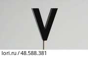 Black letter 'V' sign on wooden stick against plain background. Стоковое AI-видео, аниматор KATERINA AI / Фотобанк Лори