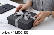 Top view of luxury unboxing scene with hands opening matte black packaging. Вид сверху на  сцену распаковки с руками, открывающими матовую черную упаковку. Стоковое AI-изображение, AI-художник Katsiaryna Repich / Фотобанк Лори