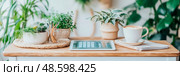 Creative workspace with greenery, digital tablet and coffee cup, perfect for relaxation and a stimulating work environment. Стоковое AI-изображение, AI-художник Данила Большаков / Фотобанк Лори