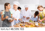 Woman calms down sad girl who cant beat raw eggs properly in cooking class. Стоковое фото, фотограф Яков Филимонов / Фотобанк Лори