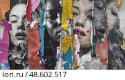 Several torn posters are pasted haphazardly on the side of a building, creating a chaotic and fragmented appearance. Стоковое AI-изображение, AI-художник Данила Большаков / Фотобанк Лори