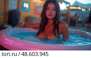 A young woman enjoys a soak in a hot tub, surrounded by colorful lights and a relaxed summer atmosphere during the evening. Стоковое AI-изображение, AI-художник Данила Большаков / Фотобанк Лори