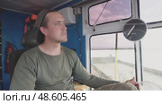 A male crane operator demonstrates his expertise as he navigates the crane's joystick with precision and focus. He is seated in the cabin, clearly engaged in his task as he operates heavy machinery. Стоковое видео, видеограф Владимир Разгуляев / Фотобанк Лори