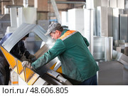 Belarus, Gomel, 25 April 2018. Factory for the manufacture of ventilation pipes.Two workers make metal ventilation pipes in the workshop at the factory. Редакционное фото, фотограф Лазаренко Светлана / Фотобанк Лори