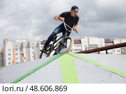 Belarus, Gomel, June 24, 2018. Central park. Extreme driving a bicycle.A dangerous trick on a bicycle against the backdrop of the city. Редакционное фото, фотограф Лазаренко Светлана / Фотобанк Лори