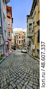 A narrow cobbled street in the old district of Istanbul with colorful facades and shops, Turkey. Vertical photo. Редакционное фото, фотограф Анна Чижова / Фотобанк Лори