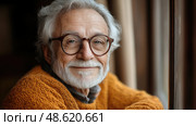 A cheerful senior man with gray hair and a beard sits next to the window, enjoying the sunlight and reflecting on his day. Стоковое AI-изображение, AI-художник Данила Большаков / Фотобанк Лори